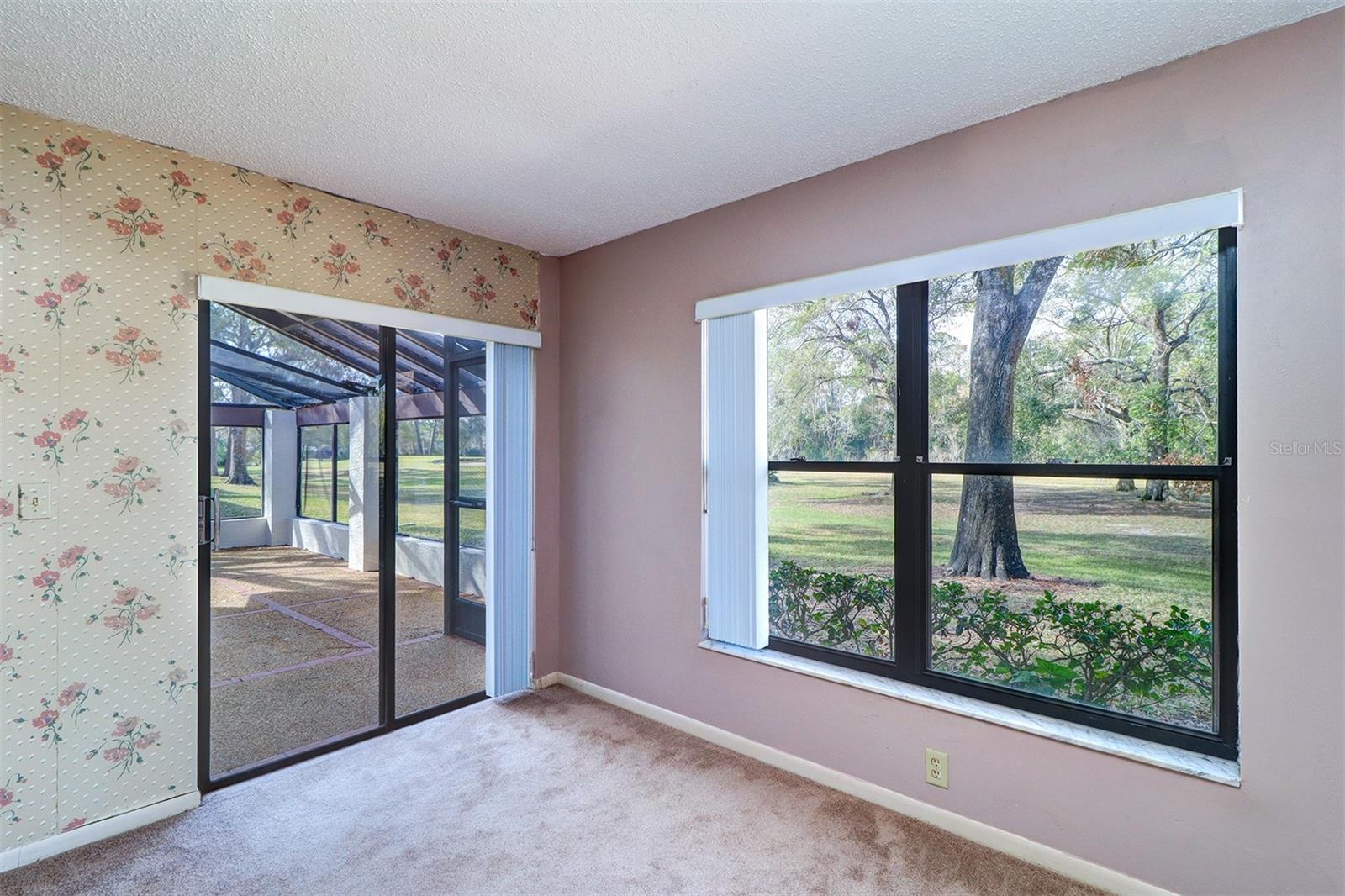 View of golf course from primary bedroom slider and large bedroom window