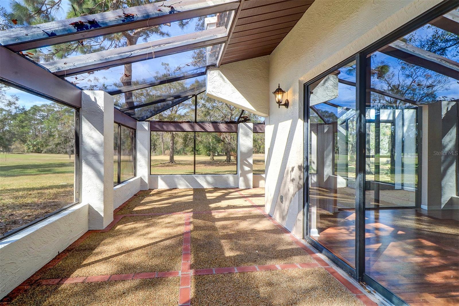 Wrap around screened lanai with river rock flooring