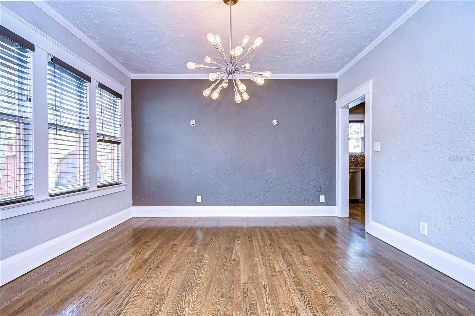 Dining room features gorgeous array of windows, crown molding, and PLENTY of space!