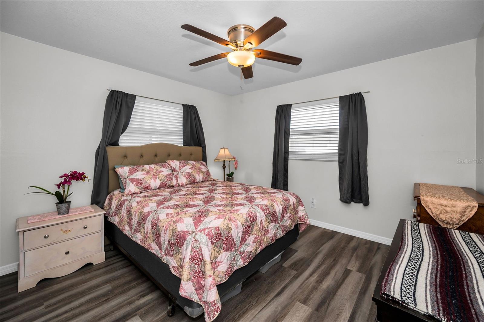 Spacious second bedroom with ceiling fan and windows for natural light.