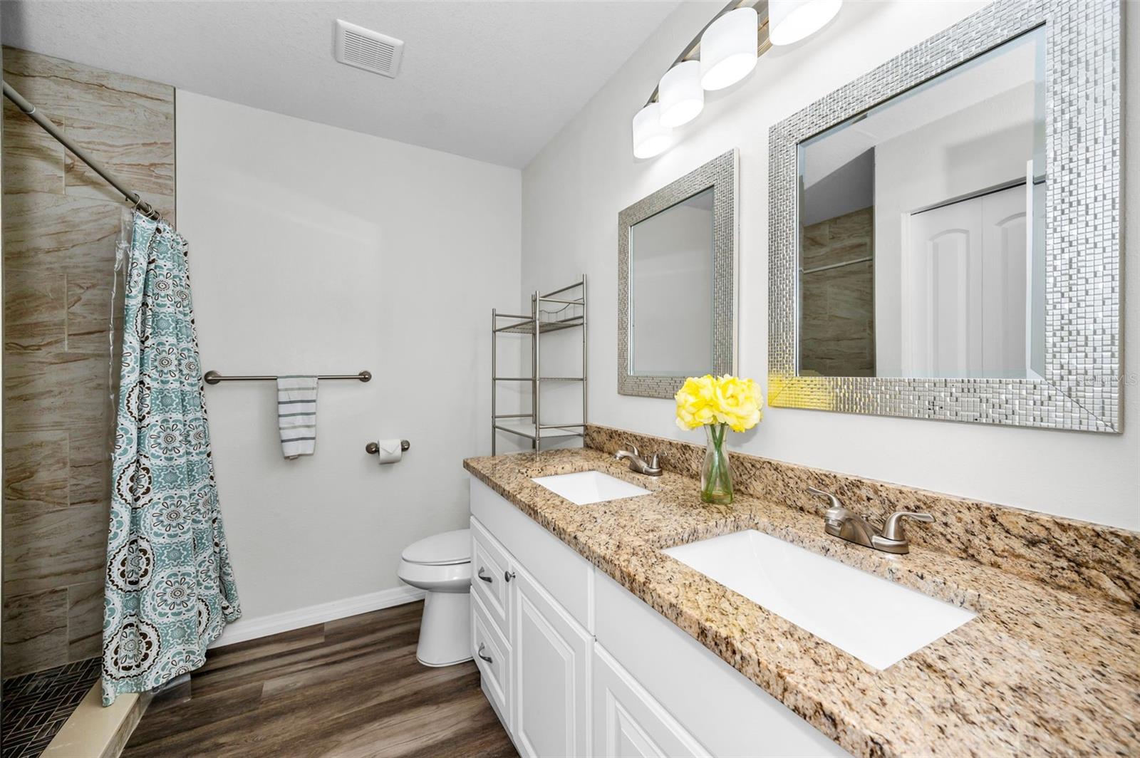 Updated second bathroom with large vanity, dual sinks, extra granite countertop space and step-in shower.