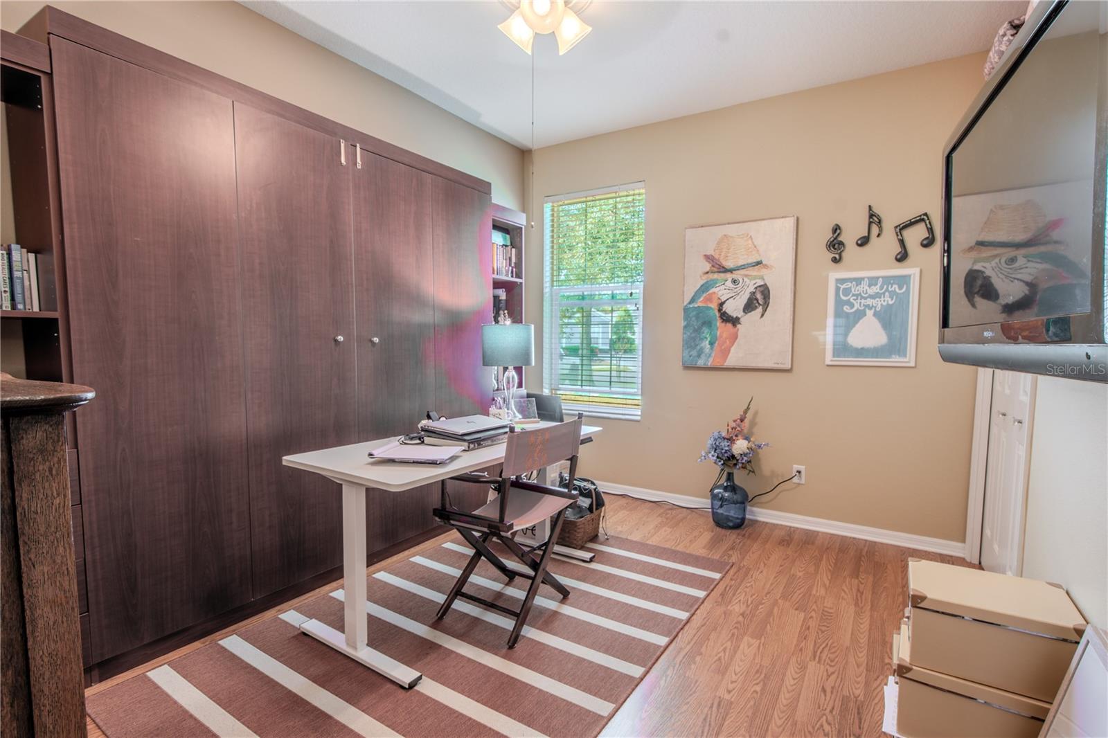 Bedroom 2  is currently used as a home office. It has a ceiling fan with light kit, built in closet and wood laminate floor.