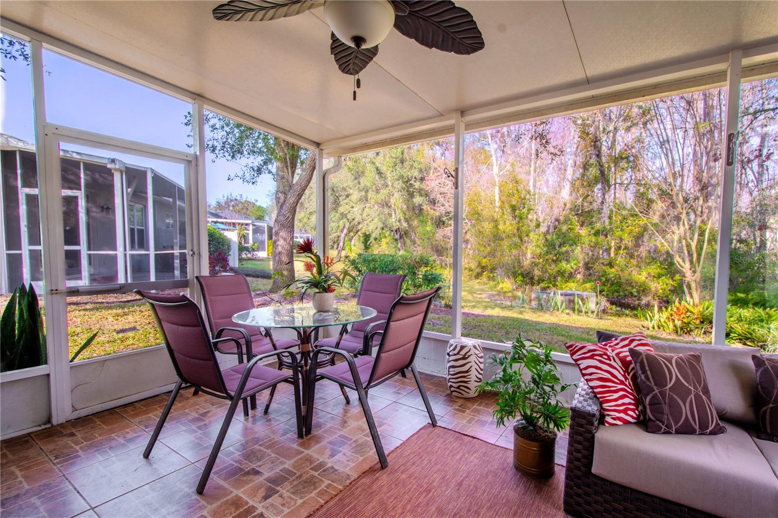 The screened in lanai features tile flooring a and a ceiling fan for year round enjoyment.