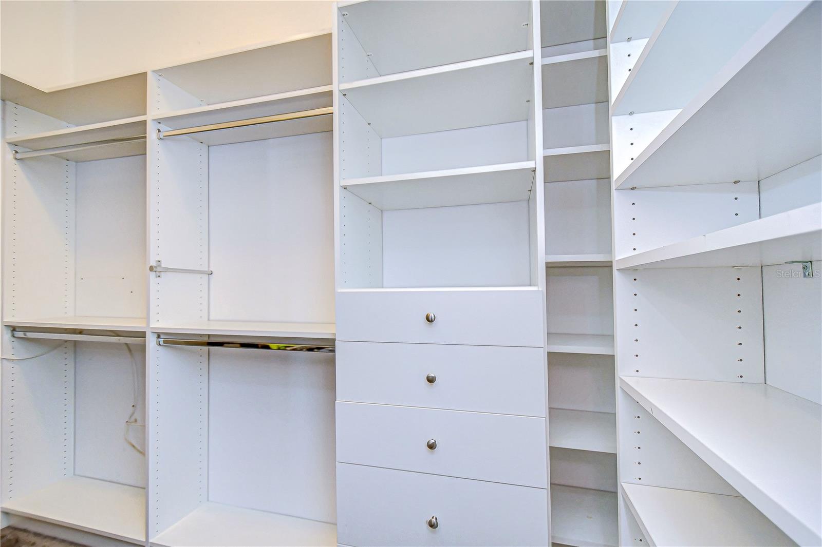 Long and deep primary bedroom closet with custom organizers