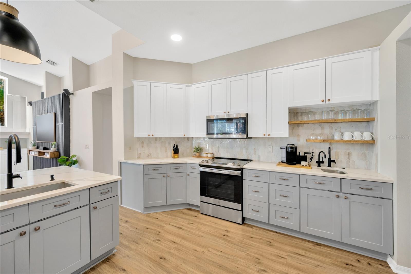 Kitchen is equipped with quality cabinetry with lots of drawer storage, high-end stainless steel appliances, and a stylish tile backsplash.