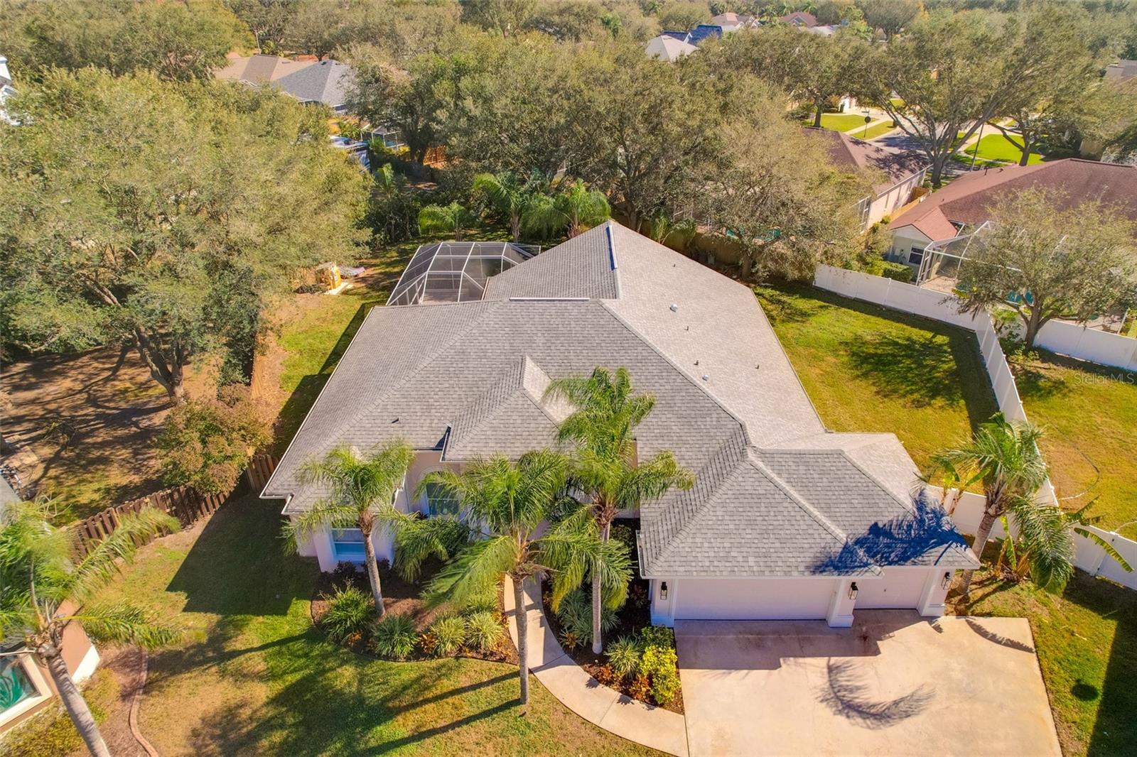 Aerial view of over-sized pie-shaped completely fenced lot.