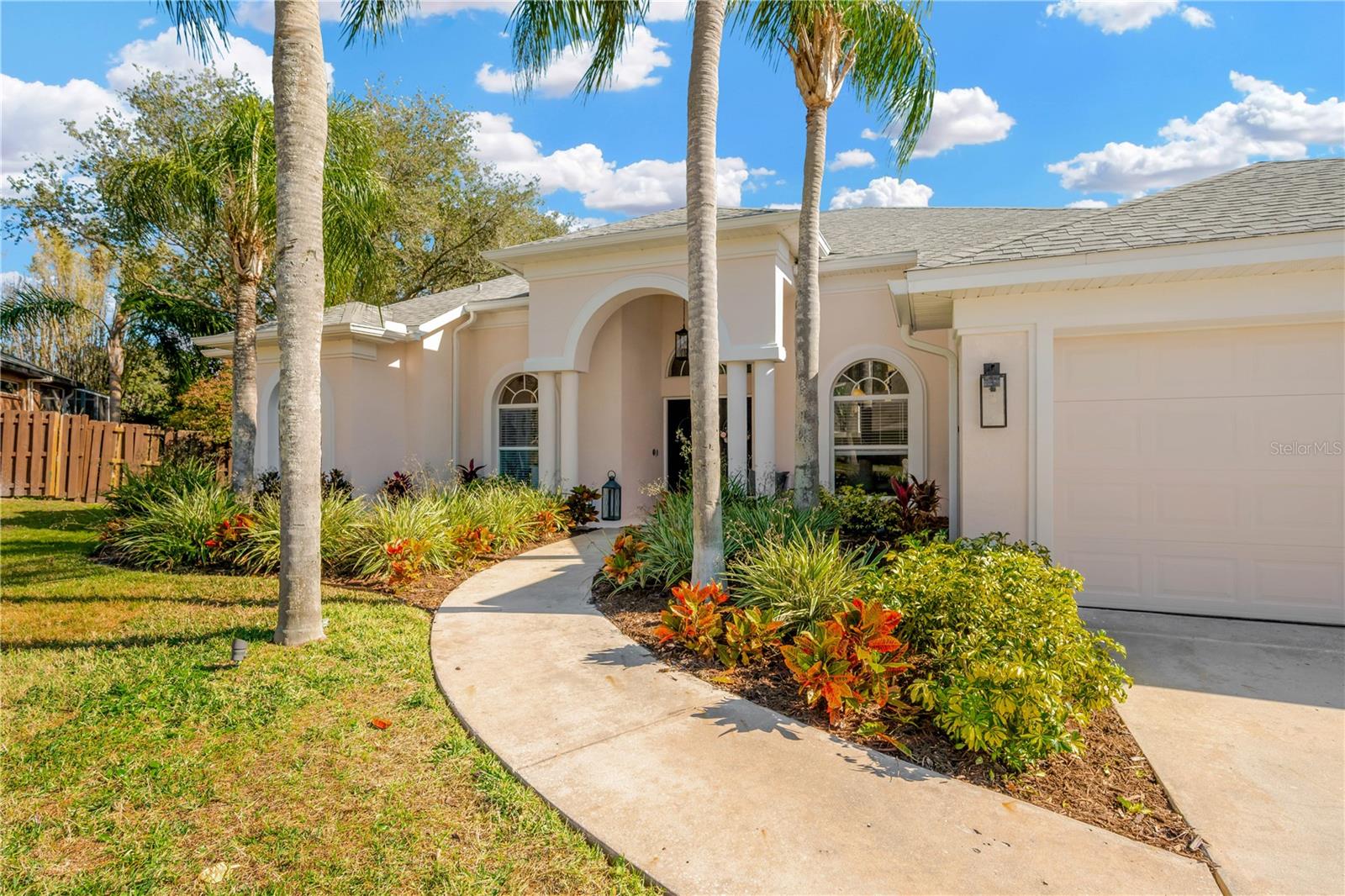 Stunning curb appeal welcomes you with updated florida friendly landscaping, landscape lighting, upgraded exterior lighting fixtures,  and revamped irrigation system and gutters.