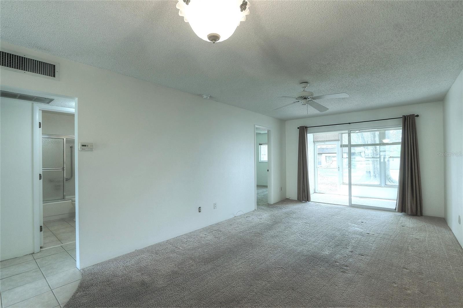 Sliding glass doors open to lovely enclosed sunroom.