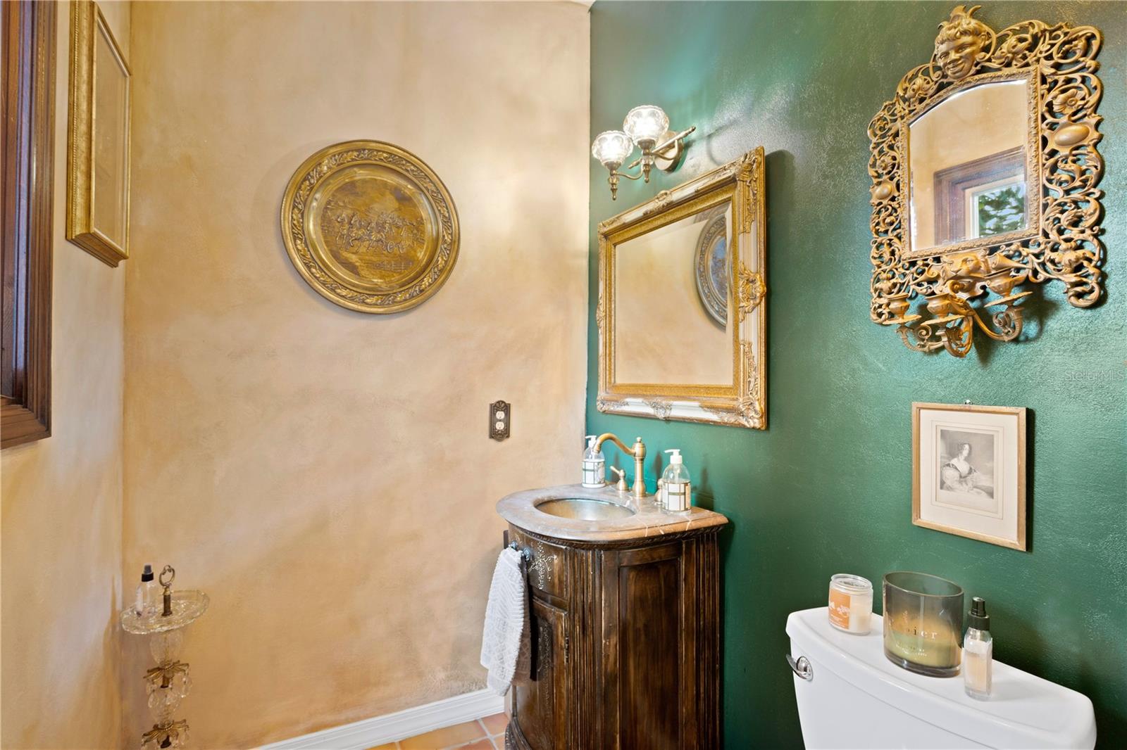 Tucked away, the hacienda powder room adds a touch of Moorish-inspired luxury, stonewall textures, Saltillo tile and timeless accents,