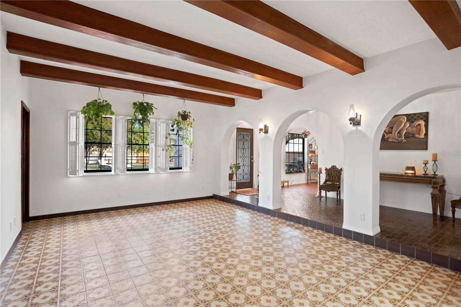 Off entry  foyer a rustic bonus room, adorned with wood beams, provides an intimate gathering space. To left of windows a laundry room corridor to garage