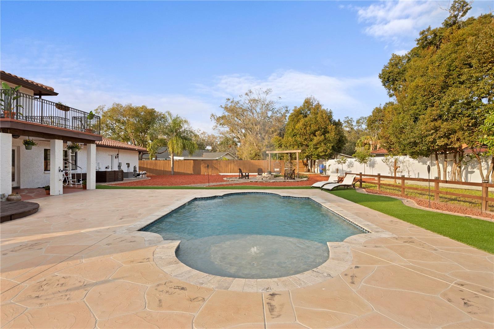 Grecian pool with water features, lighting, stamped concrete deck and Maintenace free turf surrounding