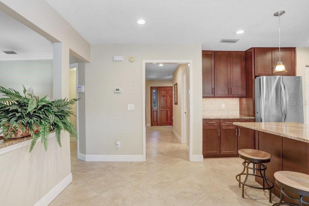 Beautiful kitchen with new cabinets, backsplash, wine refrigerator, granite countertops, and stainless steel appliances