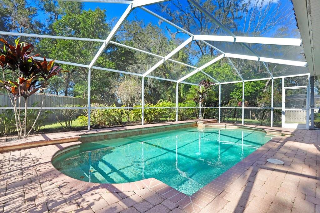 Lanai with beautiful pavers, view to back yard and pool