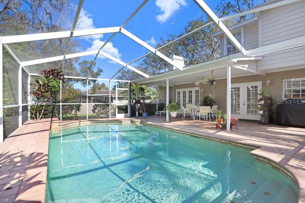 Lanai with beautiful pavers, view to back yard and pool