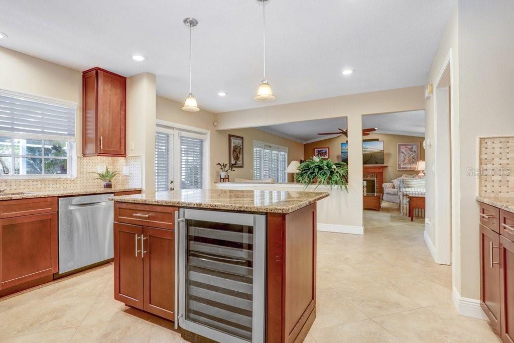 Beautiful kitchen with new cabinets, backsplash, wine refrigerator, granite countertops, and stainless steel appliances