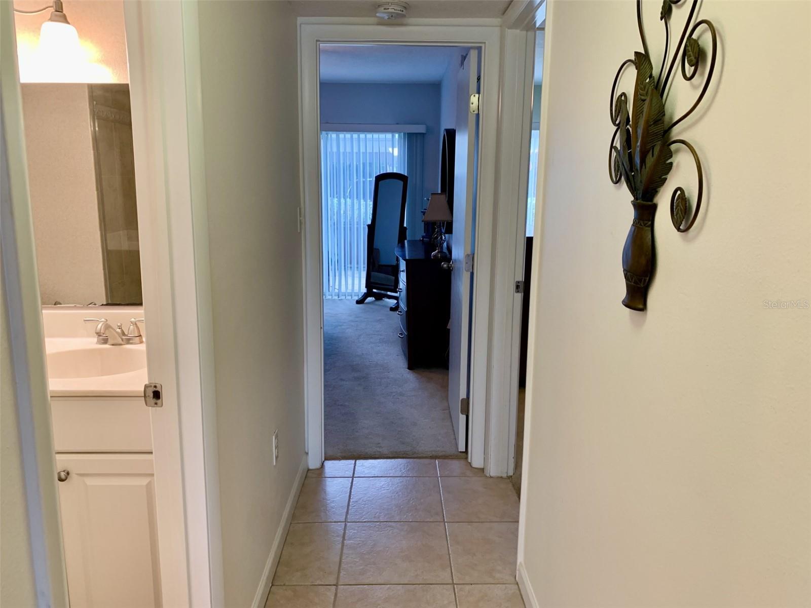 Hallway to bedrooms. Storage immediately to the left, bathroom forward left and 2 bedrooms at end