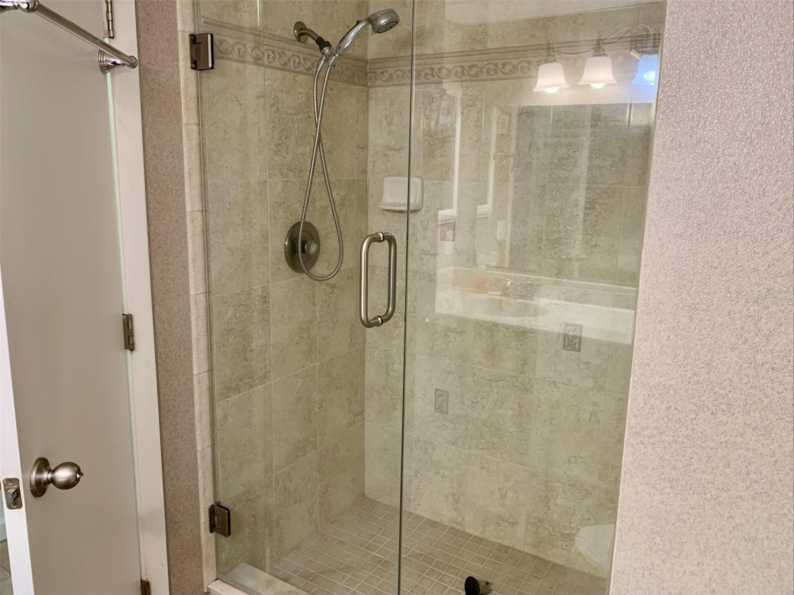 Hall bath has updated shower with frameless glass