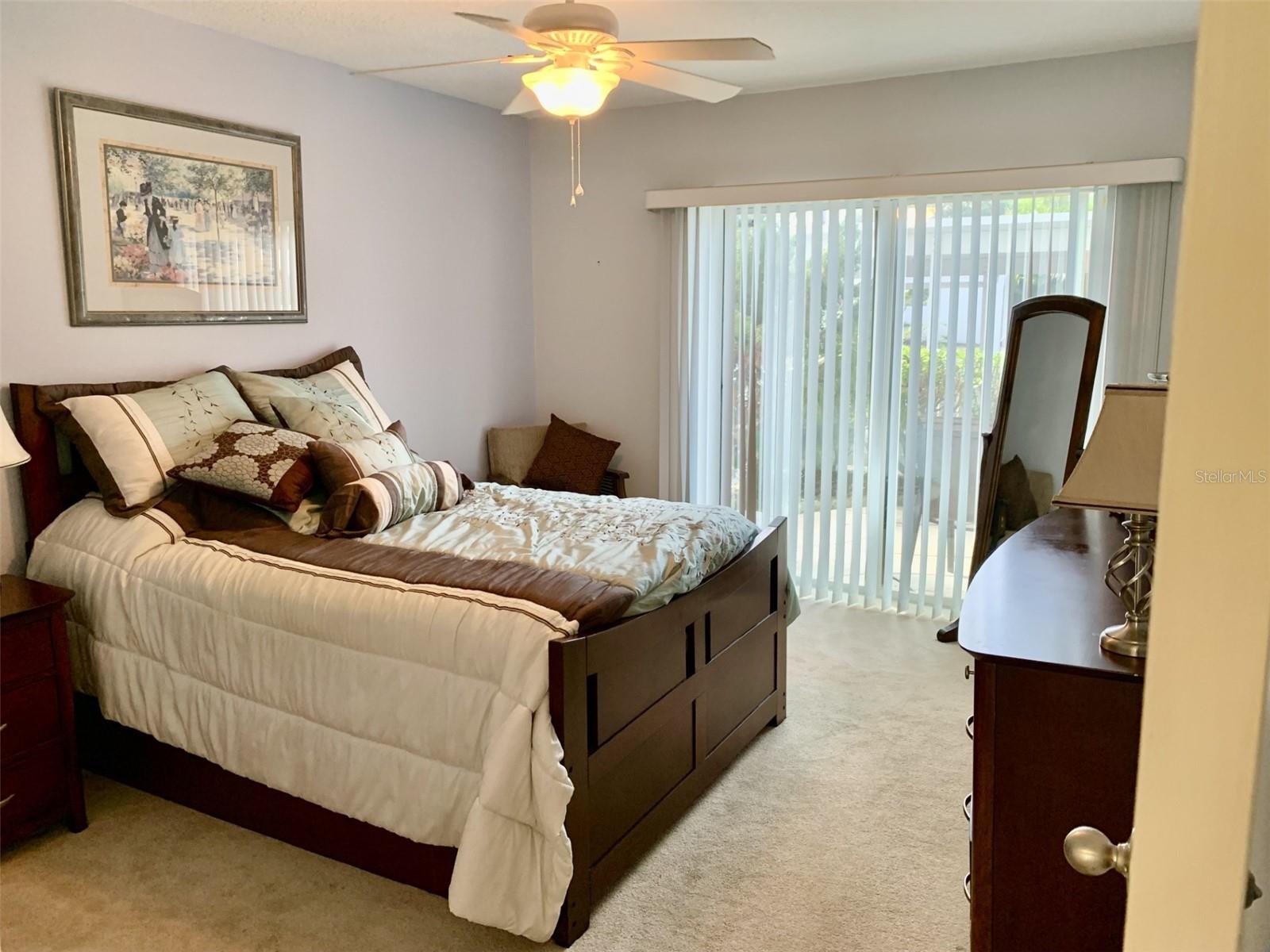 Spacious bedroom 2 with ceiling fan with access to front patio