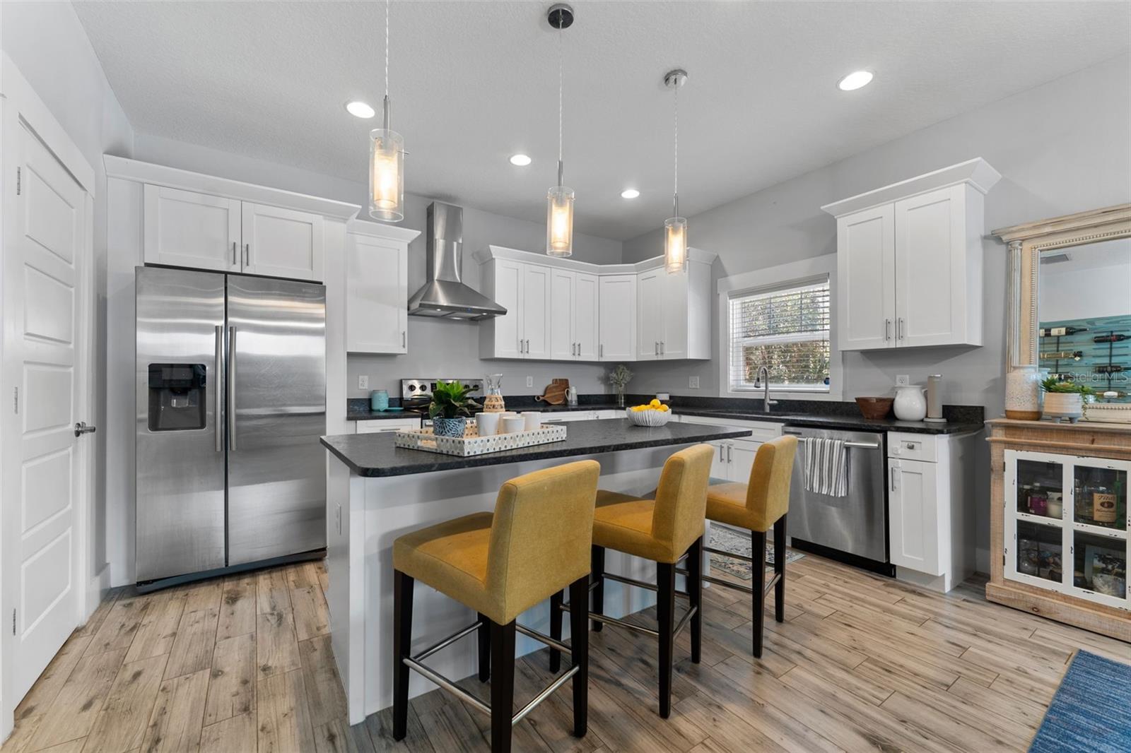 Leathered granite countertops, wood-look tile flooring and high ceilings.