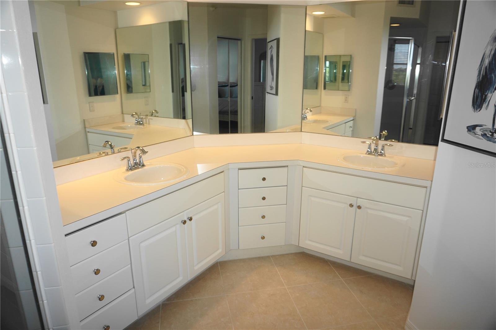 The ensuite bathroom features dual sinks and lots of cabinets . . .