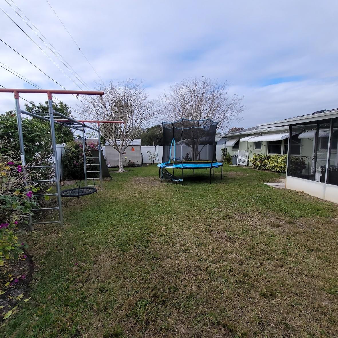 Jungle Jim, ladders, slide, and swing that is cemented into the ground and the grandchildren's trampoline.