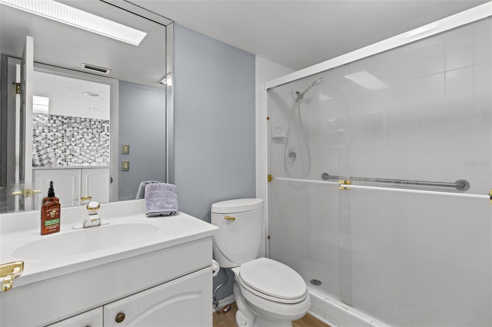 The guest bathroom is designed with a tiled shower and has been updated.