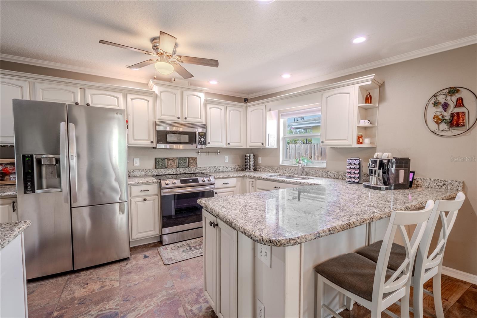 The kitchen features  breakfast bar, tile flooring and wood cabinetry with soft close cabinets and drawers.