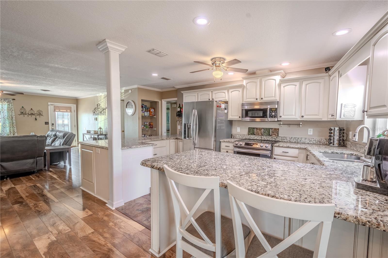 The kitchen features a suite of stainless steel appliances including ThinQ French door refrigerator with icemaker and water dispenser and a Think Q electric range with air fryer and convection oven.