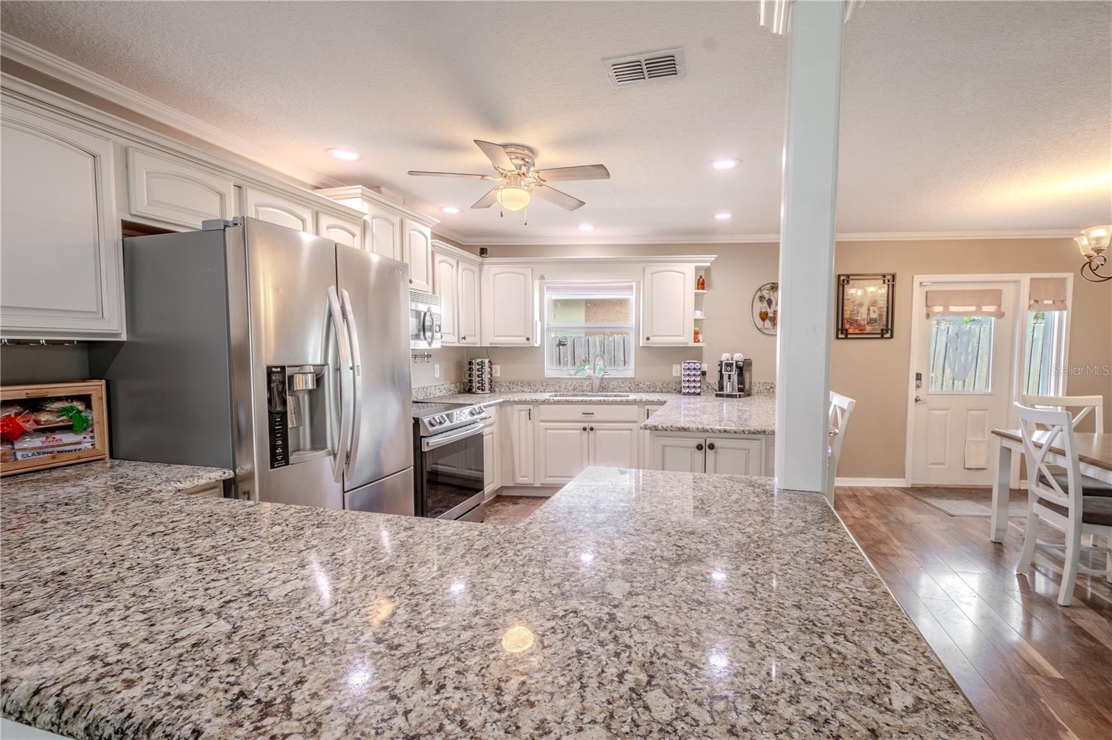 The kitchen features recessed lighting and a ceiling fan with light kit.