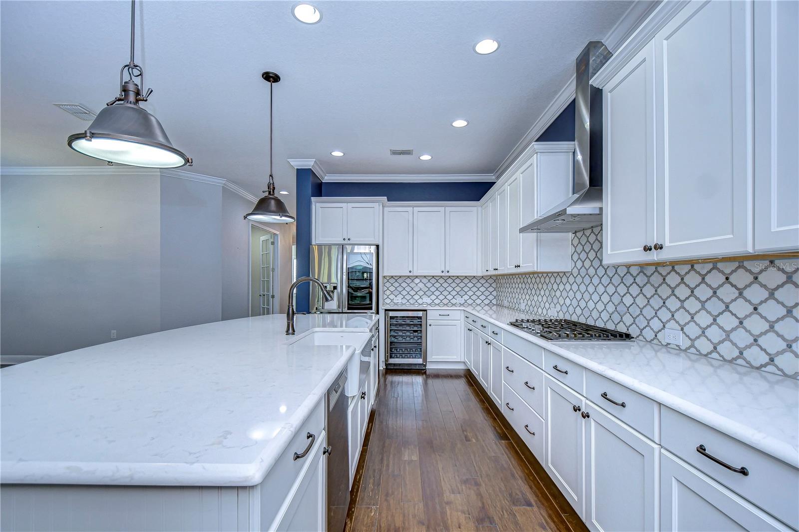 Gorgeous counter top, gas stove,and hooded range add to the luxury!