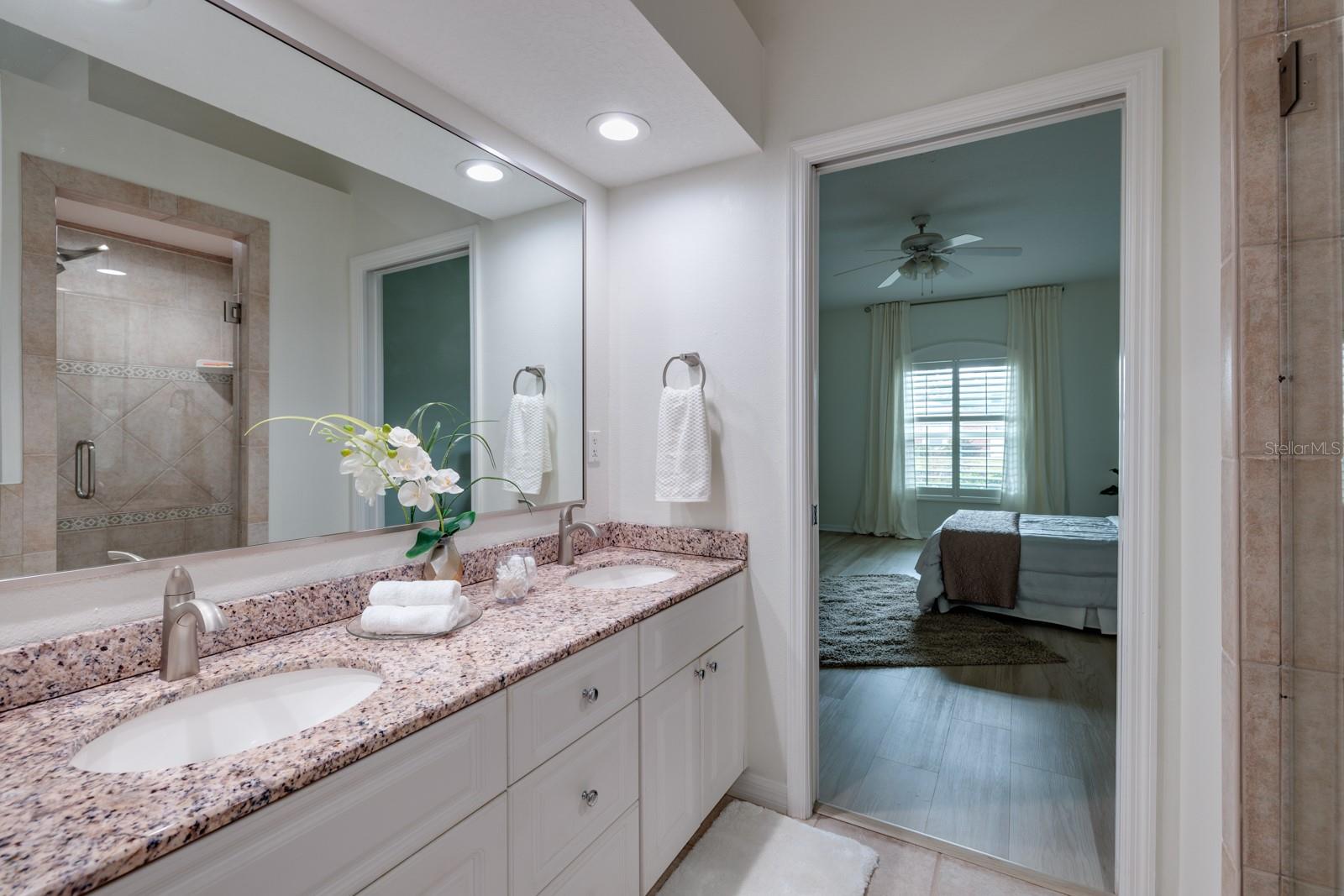 Primary bath features dual vanities, granite countertops and separate shower and tub.