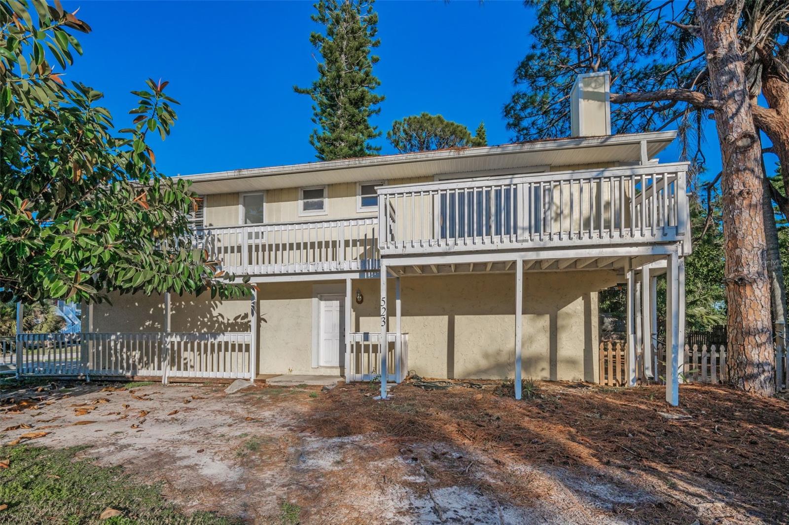 West side with sliding glass doors to deck off the Primary suite, and entrance to 1st floor