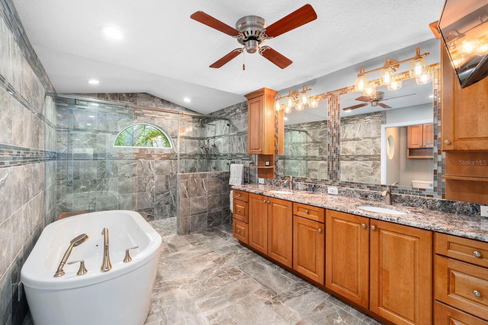 Master bathroom with large soaking tub and walk-in shower. Granite countertops. TV stays!