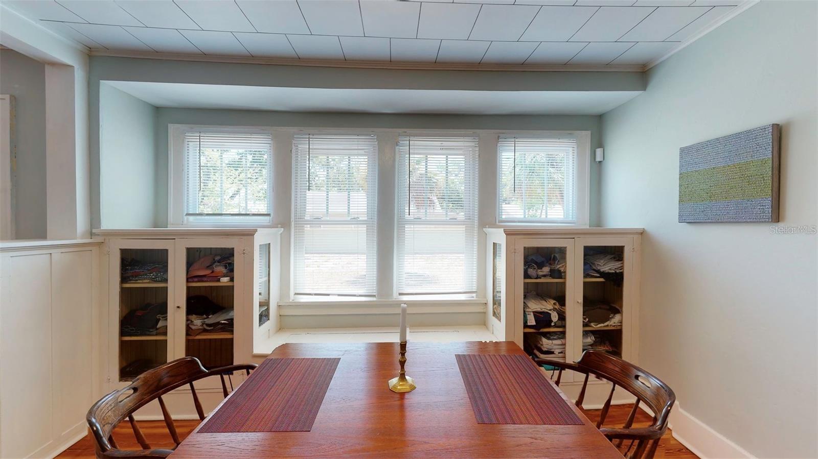 Dining room with built in hutch and storage bench and new windows.