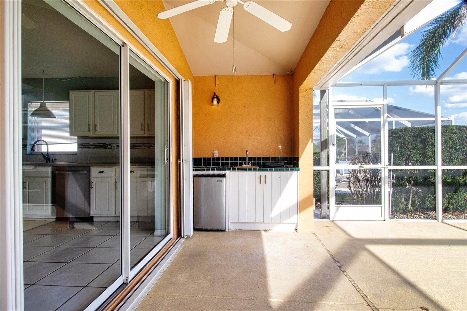 Enclosed covered Lanai w/Summer Kitchen featuring Jenn-aire electric grill, sink and mini fridge