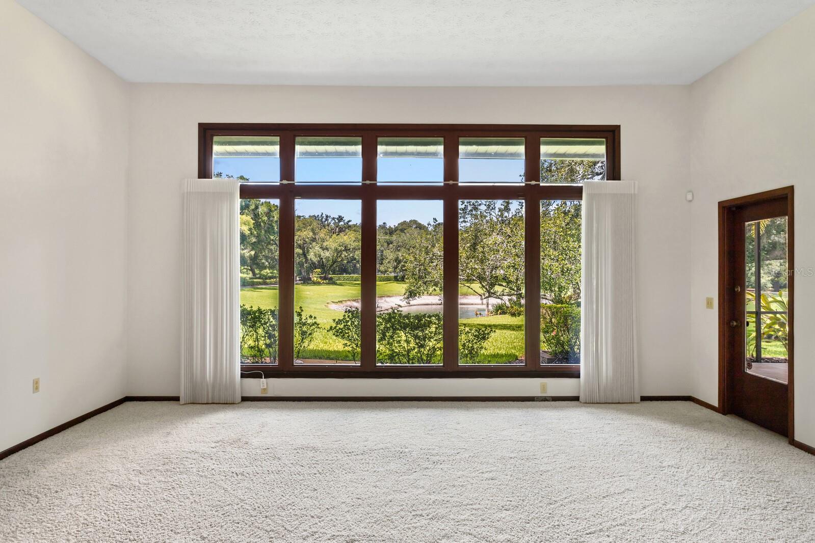 Living room is STUNNING and features beautiful windows that provide a breathtaking view of the estate.