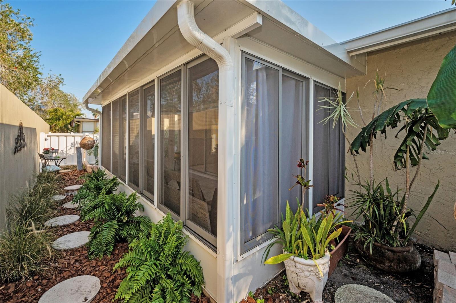 An enclosed porch with sliding windows that offers natural light galore and a cozy place to curl up to sip hot tea or read a good book...CHECK!