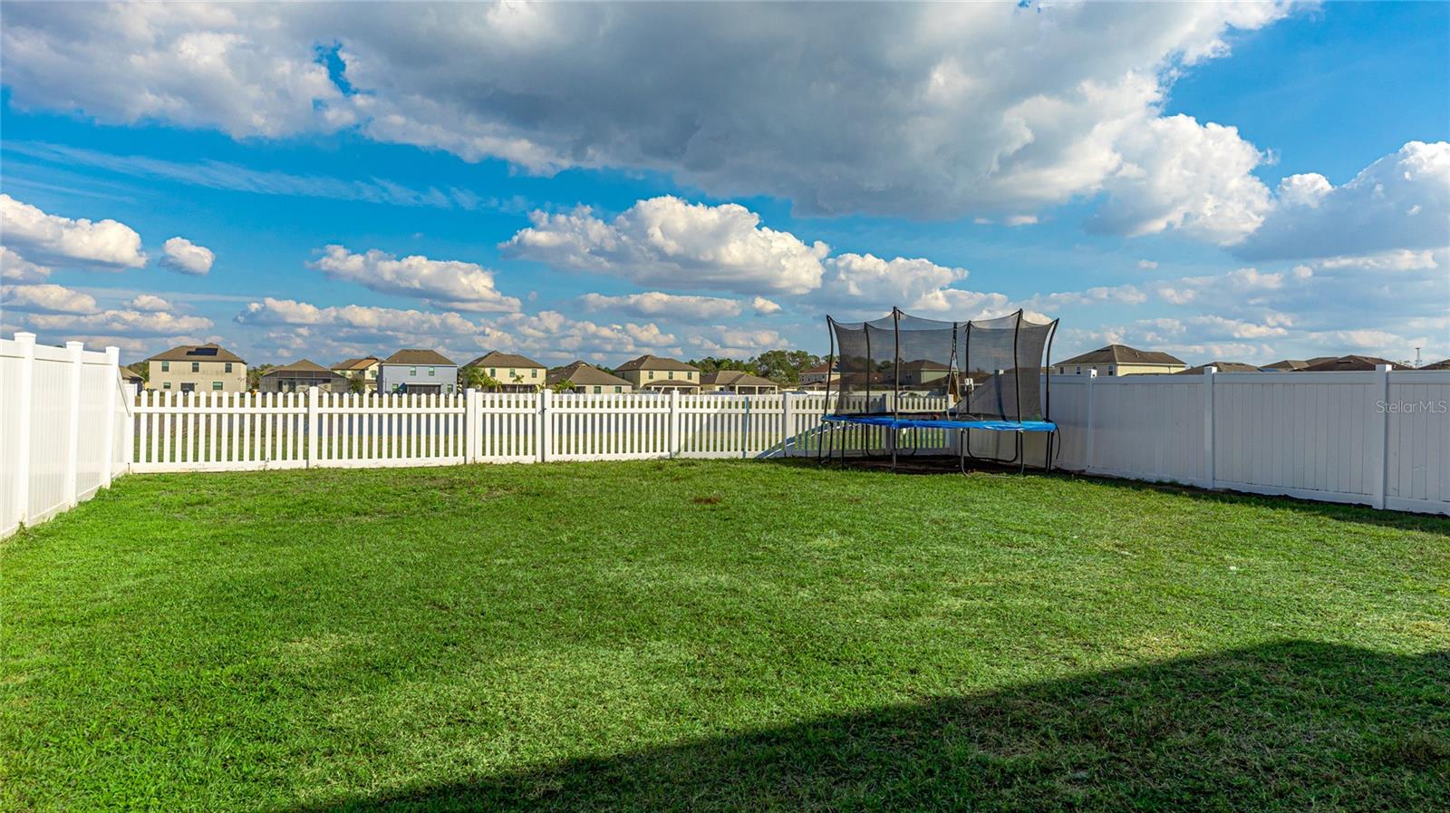 Fenced in backyard with exit gate and pond beyond