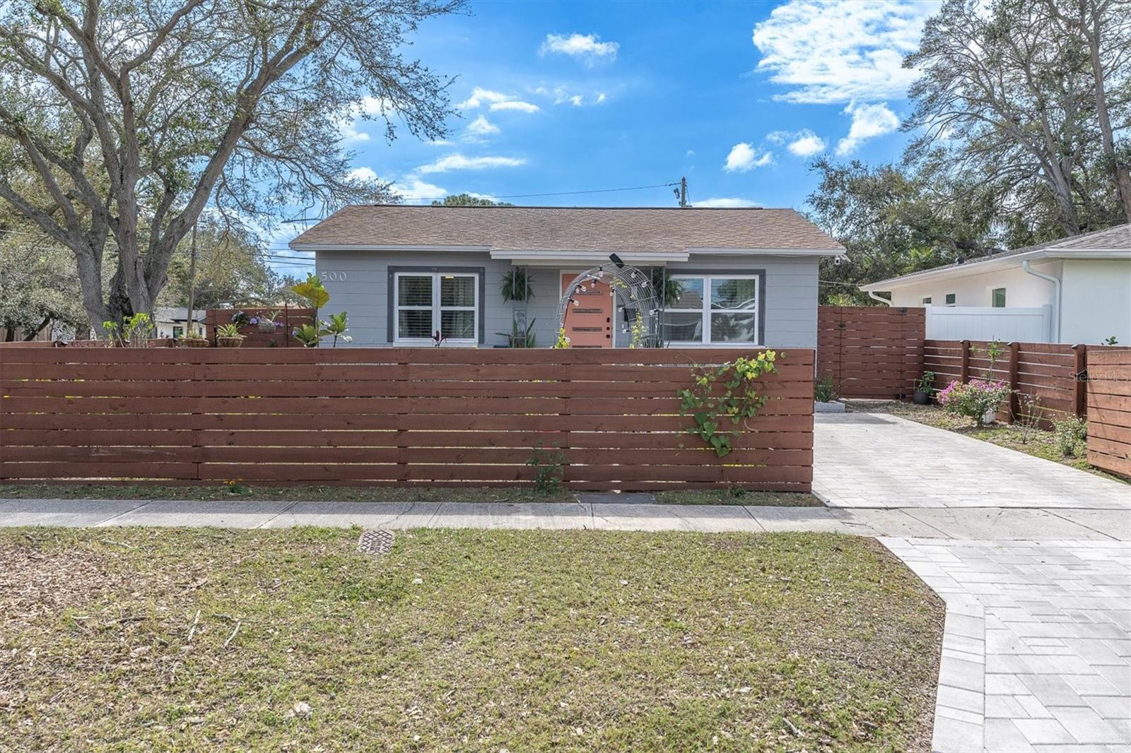 Front View of Home with Sidewalks, Fenced, and Gated Entry