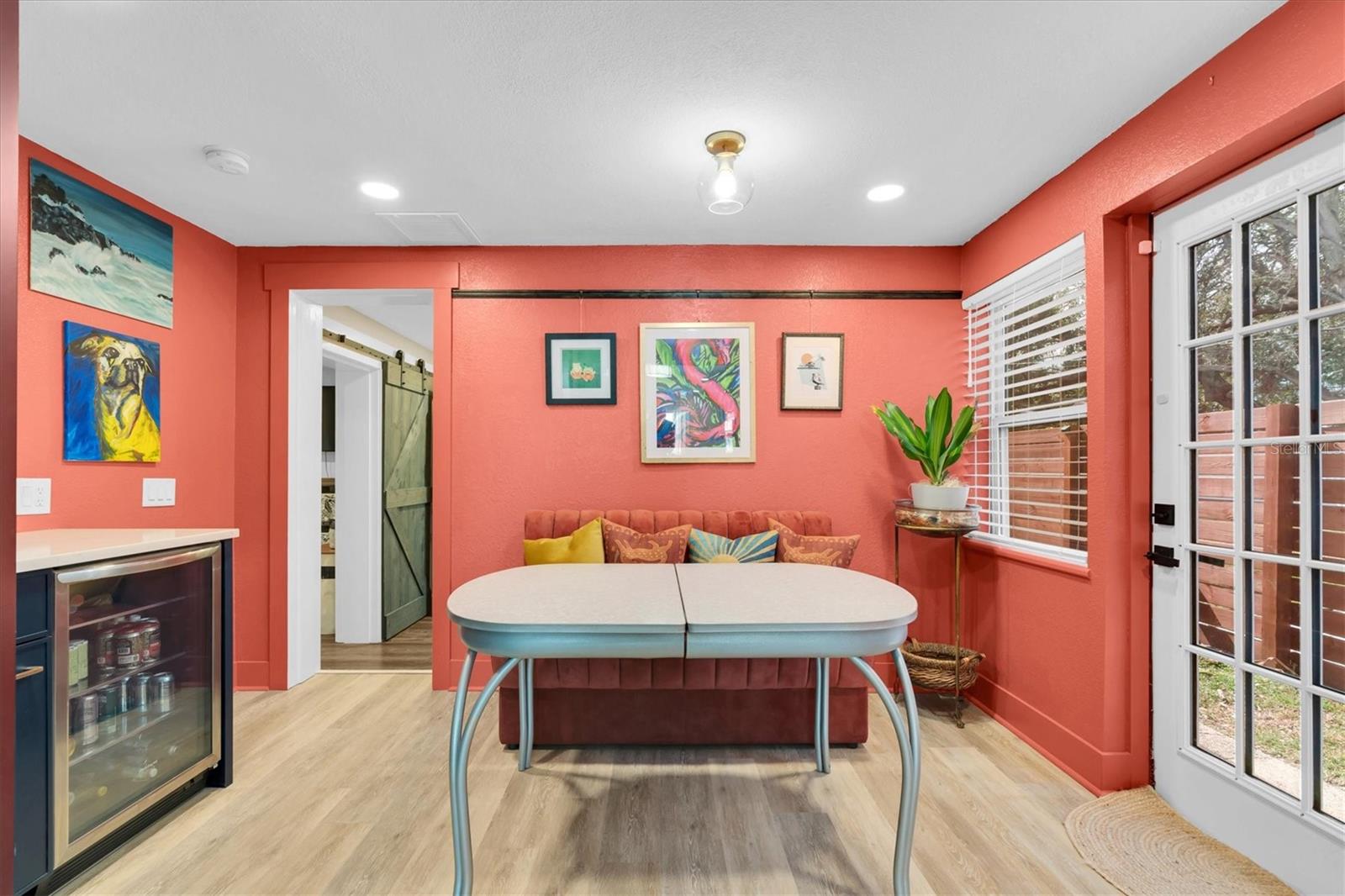 The custom wood cabinets extend to the dining room, complete with a floor-to-ceiling pantry, coffee bar with quartz countertop, floating shelves, and a beverage fridge. French door has walkway leading to back yard for entertaining.