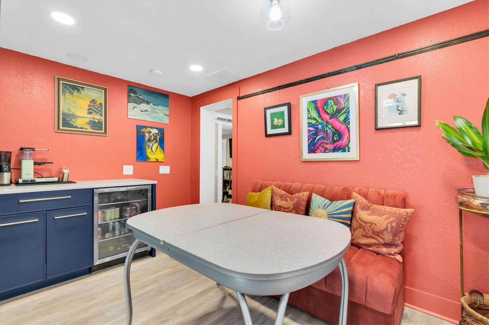 The custom wood cabinets extend to the dining room, complete with a floor-to-ceiling pantry, coffee bar with quartz countertop, floating shelves, and a beverage fridge.