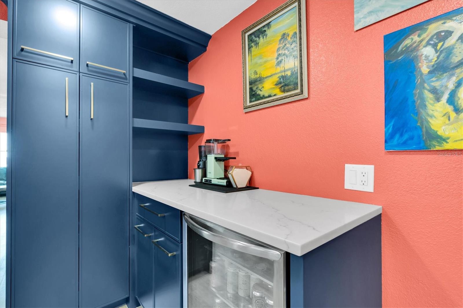 The custom wood cabinets extend to the dining room, complete with a floor-to-ceiling pantry, coffee bar with quartz countertop, floating shelves, and a beverage fridge.