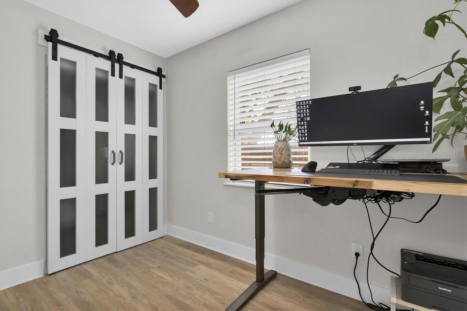 Third bedroom has luxury vinyl tile, ceiling fan, custom blinds, and beautiful bi-fold barn doors.  This  split floor plan is ideal for family, guests, or home office space.