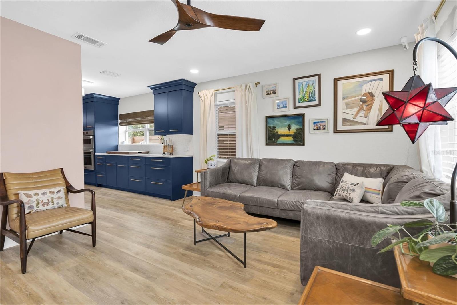 Open Living Room leading to Kitchen, Luxury Vinyl Tile, Celing Fan, Custom Blinds, and Recessed Lights