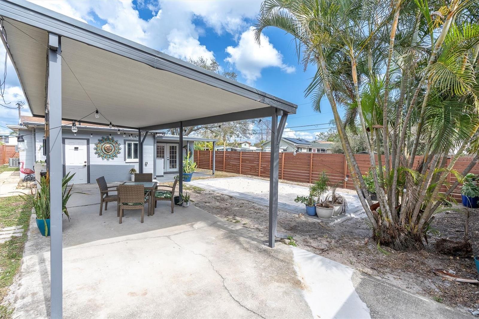 Spectacular backyard for entertaining, with privacy fence with gated entrance, covered carport for two cars.  Sandy area for soaking up the Florida sun or playing volleyball, corn hole, or the outdooor game of your choice.