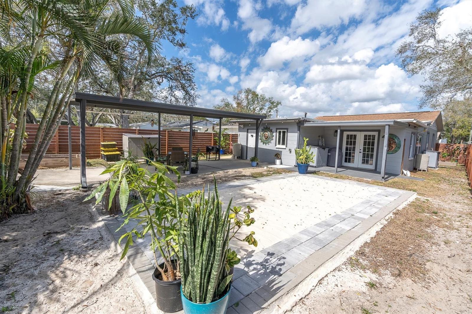 Spectacular backyard for entertaining, with privacy fence with gated entrance, covered carport for two cars.  Sandy area for soaking up the Florida sun or playing volleyball, corn hole, or the outdooor game of your choice.