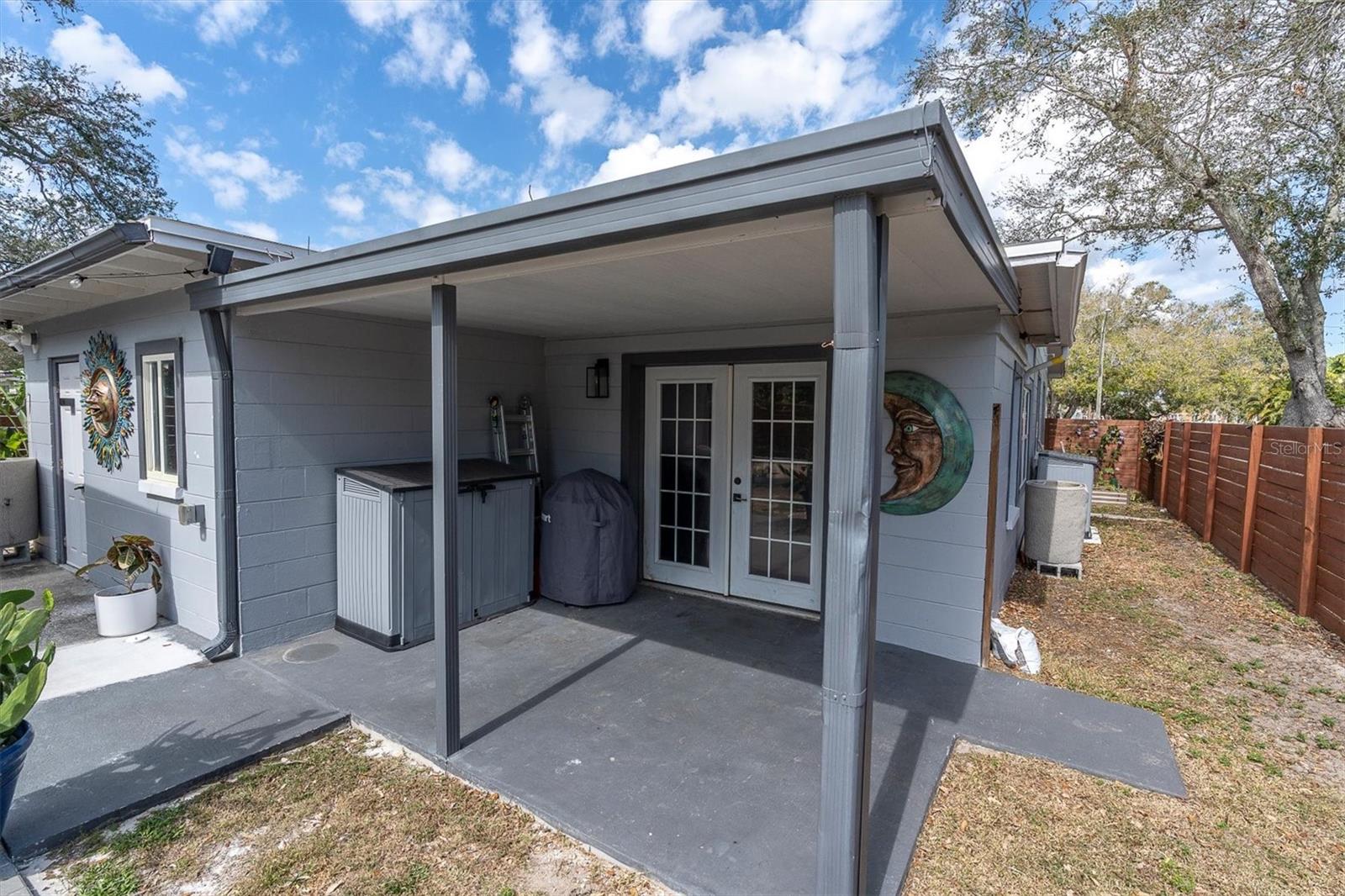 Covered back porch with french doors leading to primary suite.