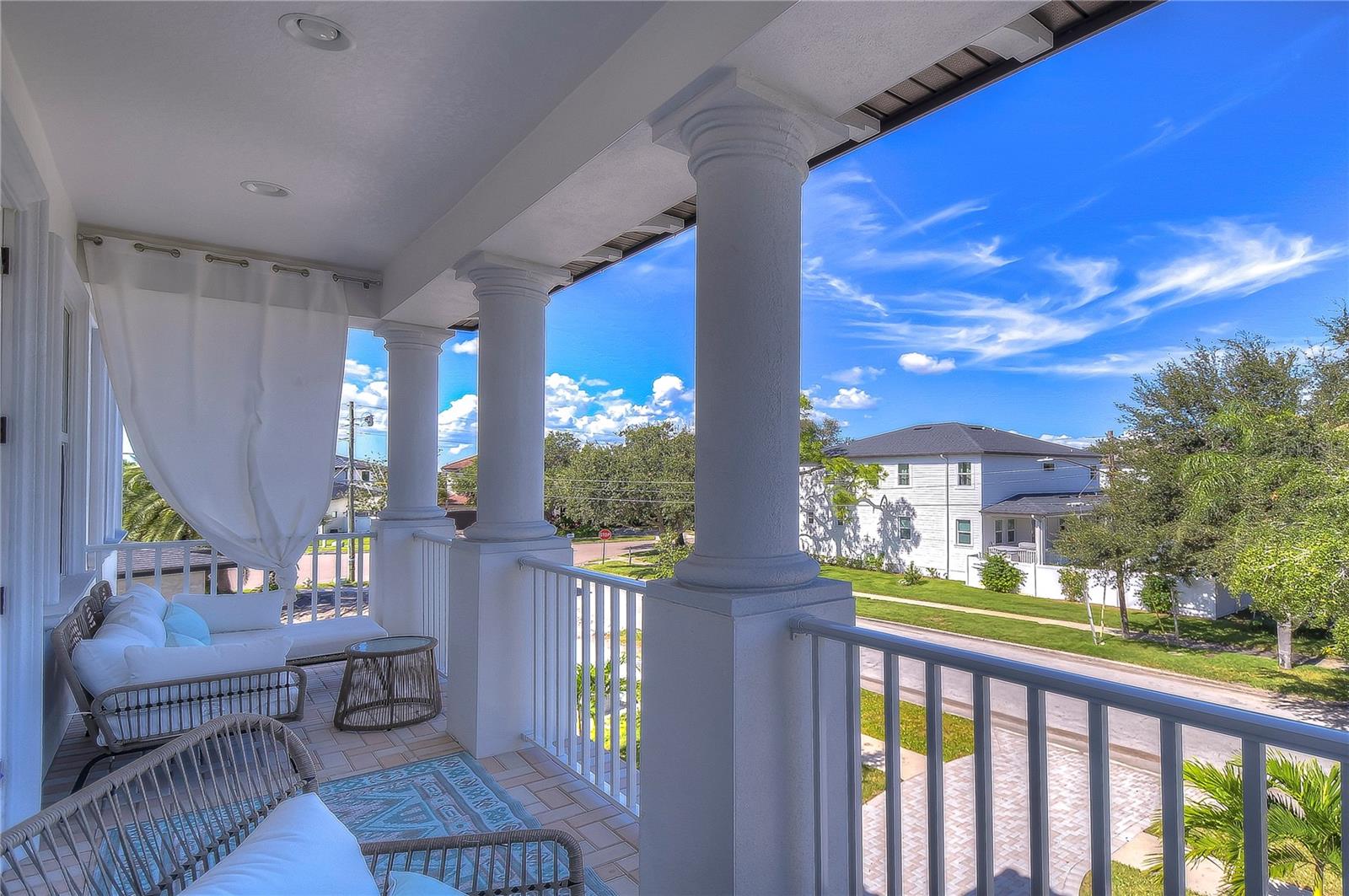 Perfect for sunny Florida afternoons, this inviting balcony offers a picturesque view of the neighborhood's lush greenery and tranquil streets.