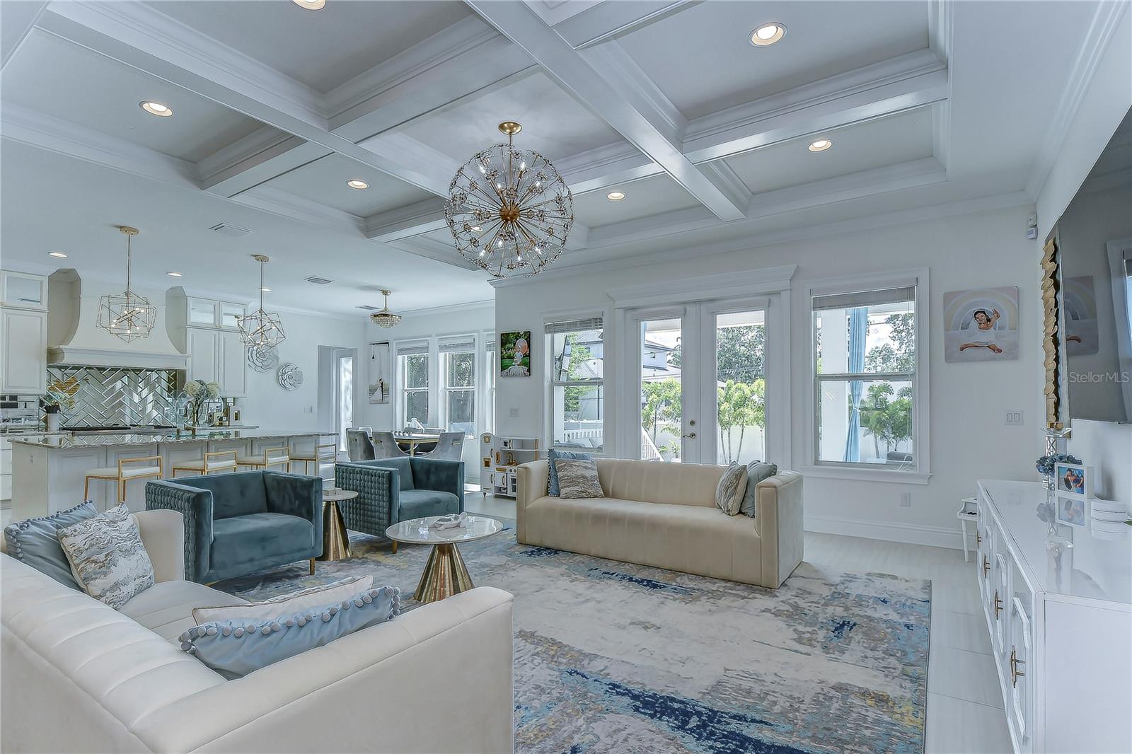 Unveiling elegance at its finest, this exquisite living space wows with sophisticated coffered ceilings, chic lighting, and expansive windows.