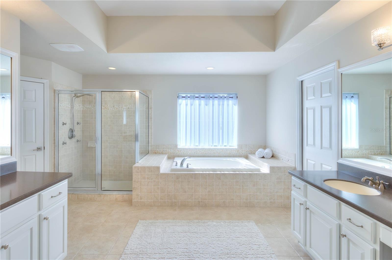 Gracious master ensuite features dual vanities & sinks, a garden tub, walk-in shower with rain head & multiple water jets, 2 walk in closets with custom built-ins & a water closet!